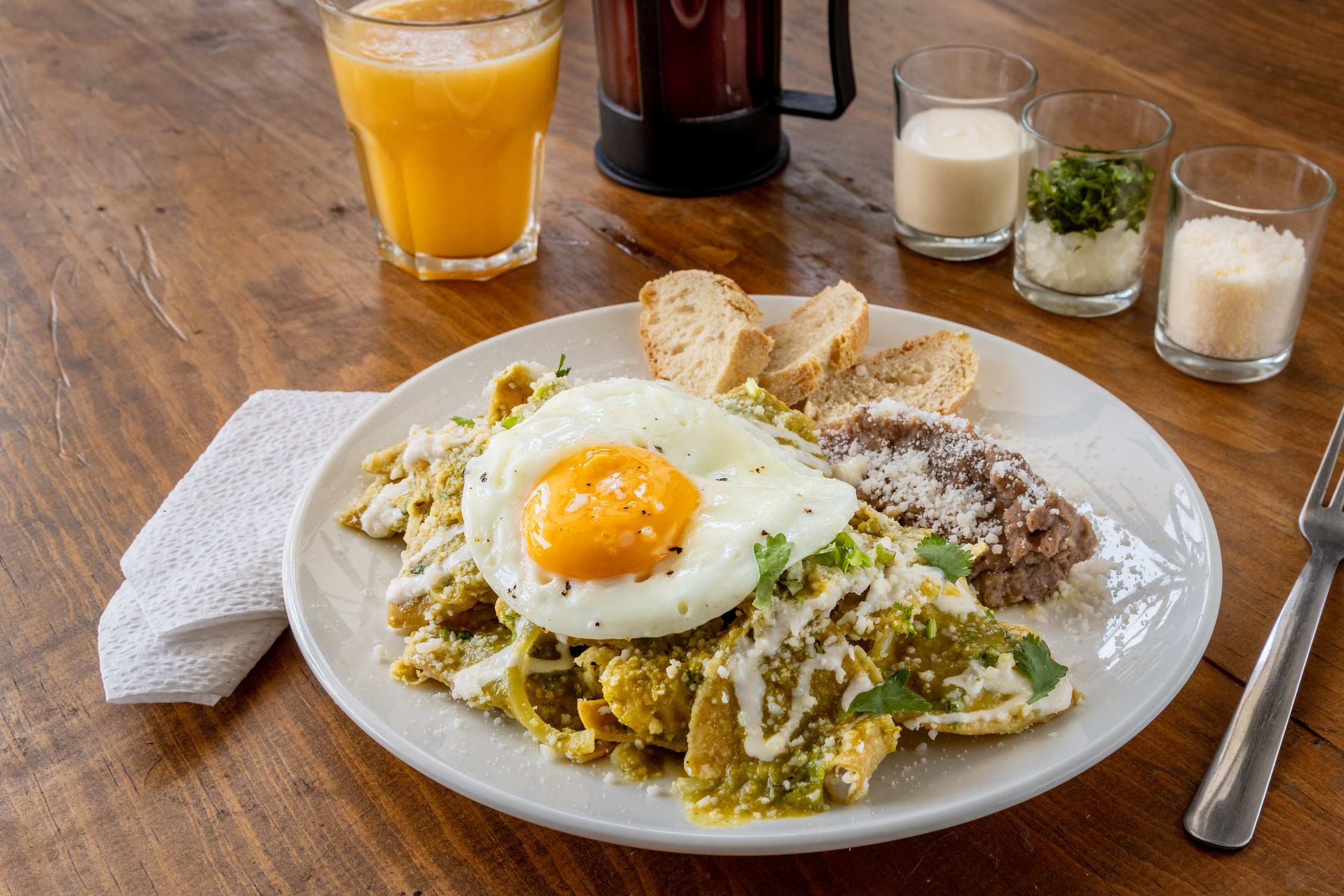 Plato de Chilaquiles Verdes Con Huevo y Frijoles Refritos